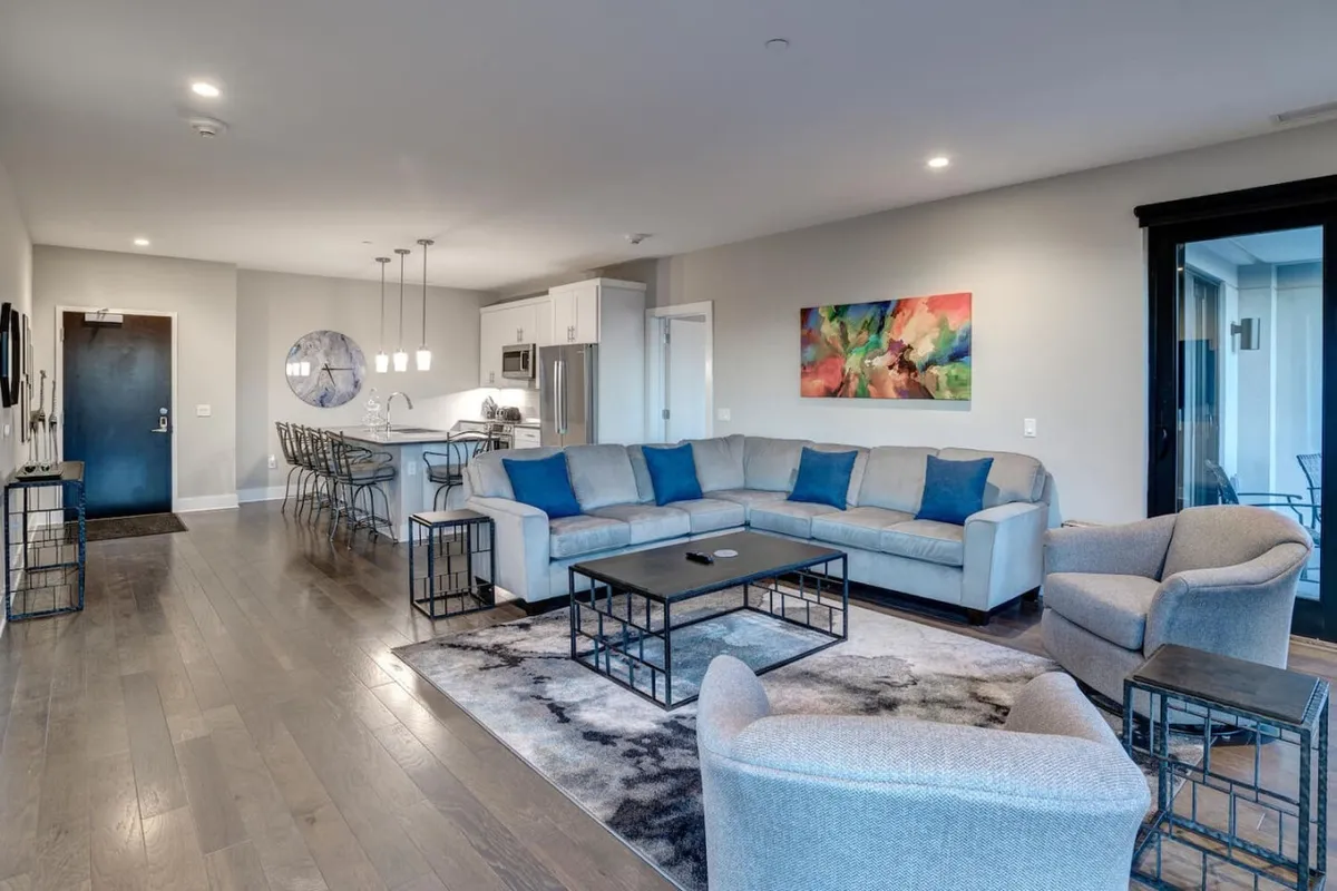 An integrated living and dining area featuring a contemporary sofa, coffee table, wall art, and a dining table. The space feels inviting and cohesive, encouraging both social gatherings and intimate meals.